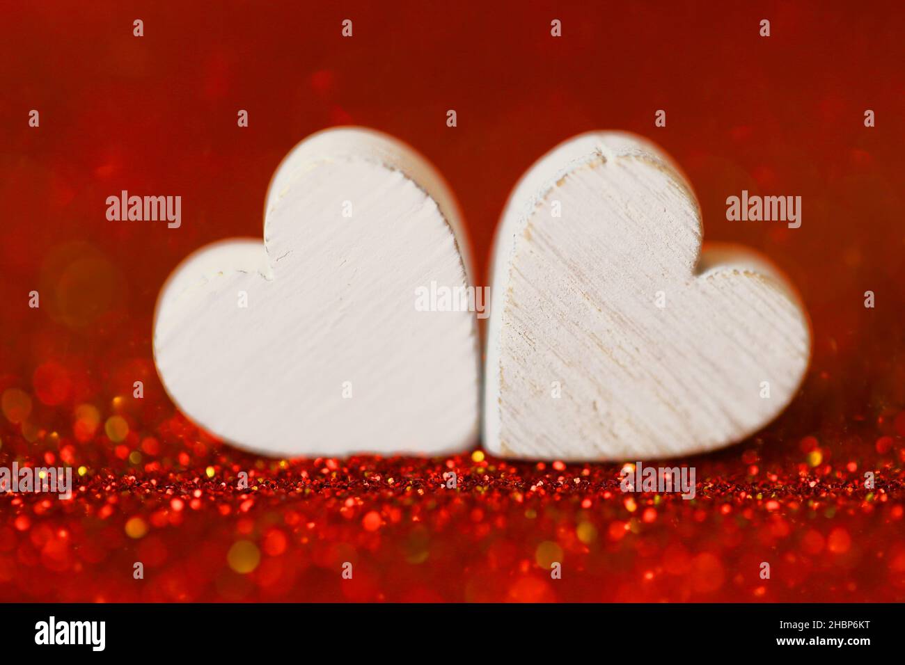 Amore Concept.San Valentino. Due cuori bianchi . Sfondo del giorno di San Valentino in toni rossi.simbolo d'amore Foto Stock