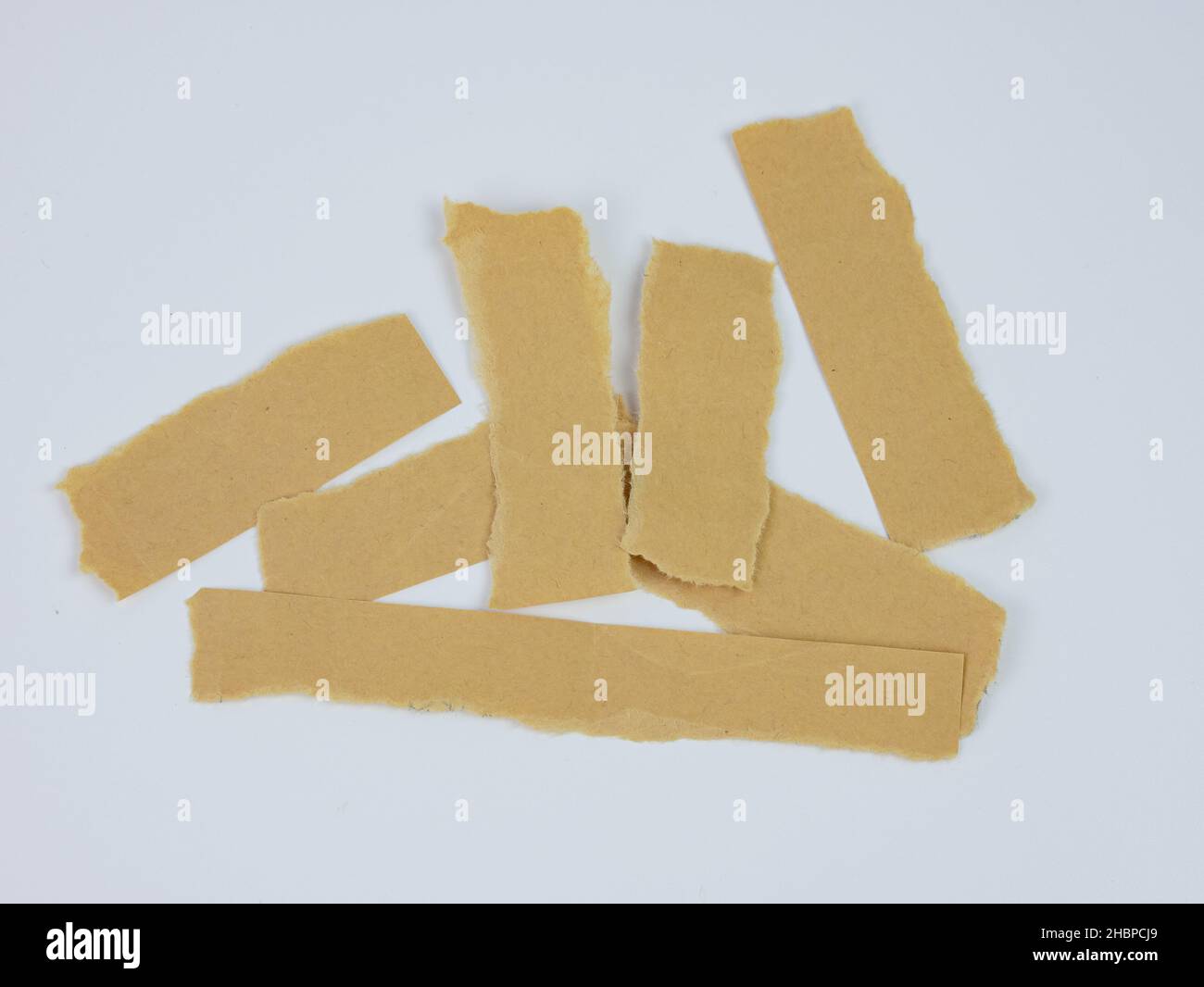 Carta bruna vera e propria strappata o strappata pezzi di carta. Carta strappata raccolta. Isolato su bianco. Foto Stock