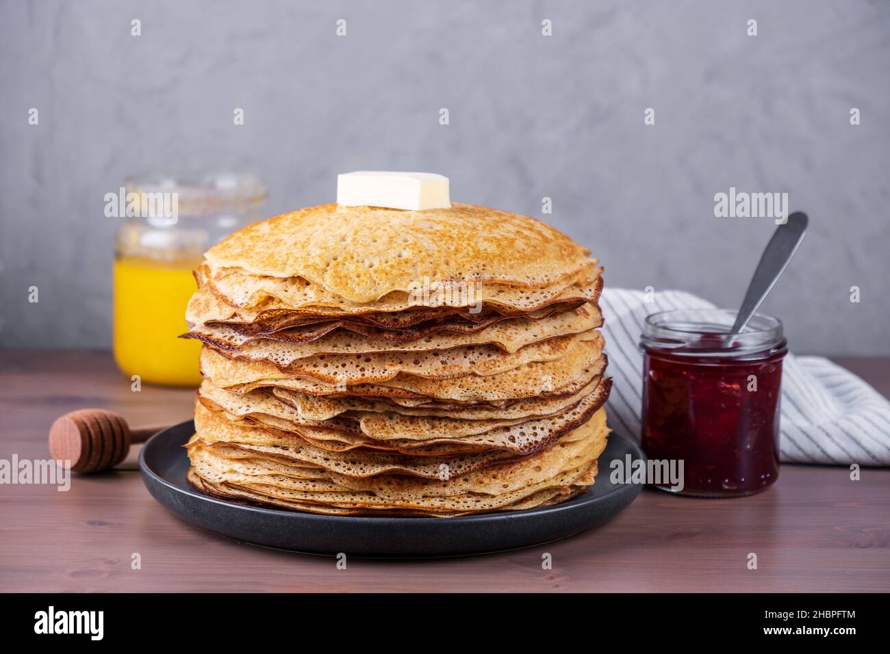 Impila di pancake appena sfornati con miele e marmellata. Cucina tradizionale russa. Shrovetide, festa popolare con cibo delizioso. Messa a fuoco selettiva, copia spa Foto Stock