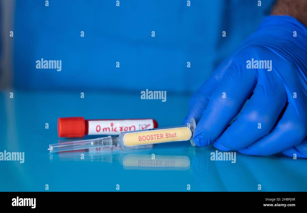 Concetto di Booster shot per omicron covid-19 variante mutata di coronavirus che mostra il posizionamento di una siringa o di un'iniezione di richiamo di fronte a omicron Foto Stock