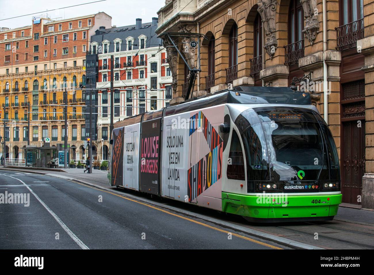 Sistema di trasporto con tram elettrico che passa nella città vecchia nel centro della città di Bilbao - regione basca del nord della Spagna Foto Stock