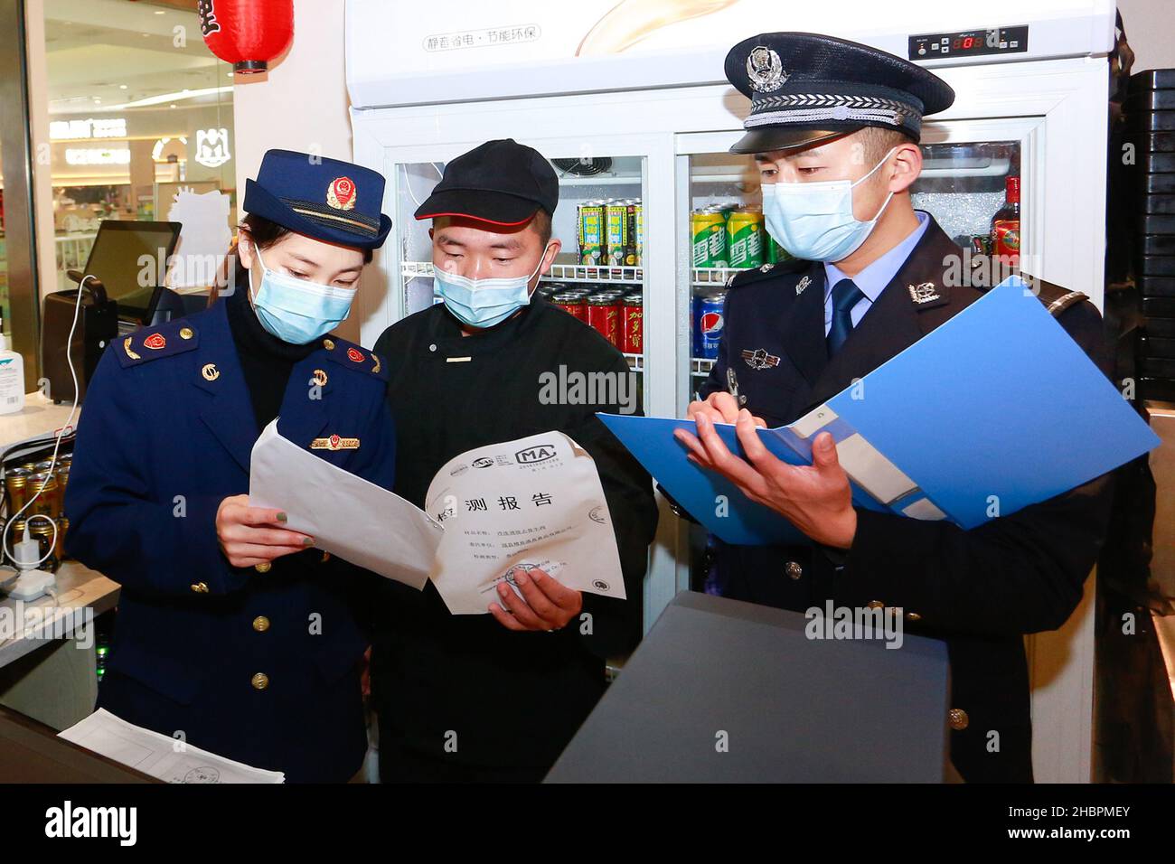ZHOUSHAN, CINA - 21 DICEMBRE 2021 - gli agenti dell'applicazione della legge controllano il rapporto dei test del cibo freddo della catena nella città di Zhoushan, provincia di Zhejiang, Cina, Foto Stock