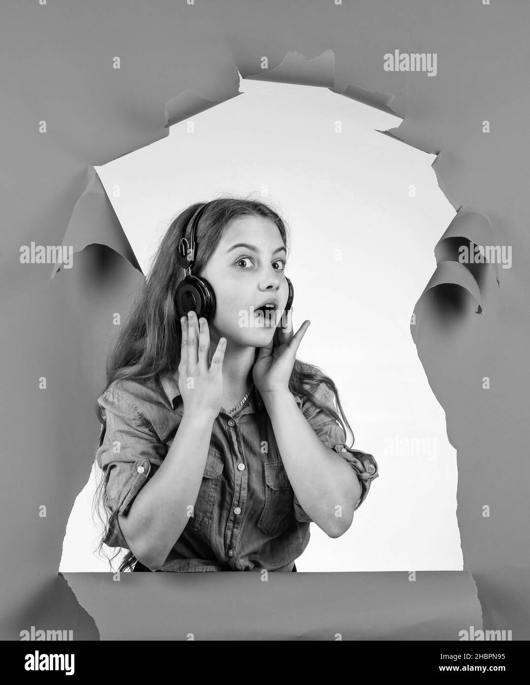 Adoro questa canzone. I bambini ascoltano la musica nelle cuffie. La tecnologia moderna nell'educazione scolastica. Imparare ascoltando l'audiolibro. La sua canzone preferita Foto Stock