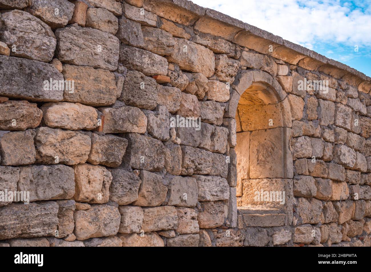 Parte di un vecchio muro di pietra con una finestra ad arco che si apre nel museo archeologico di Chersonesos Foto Stock
