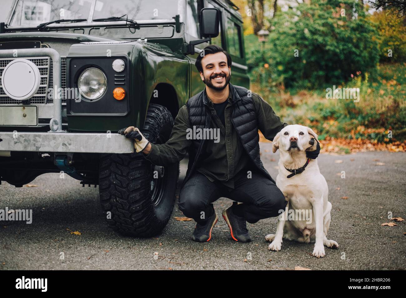 Ritratto di uomo sorridente con cane da sport utility veicolo Foto Stock
