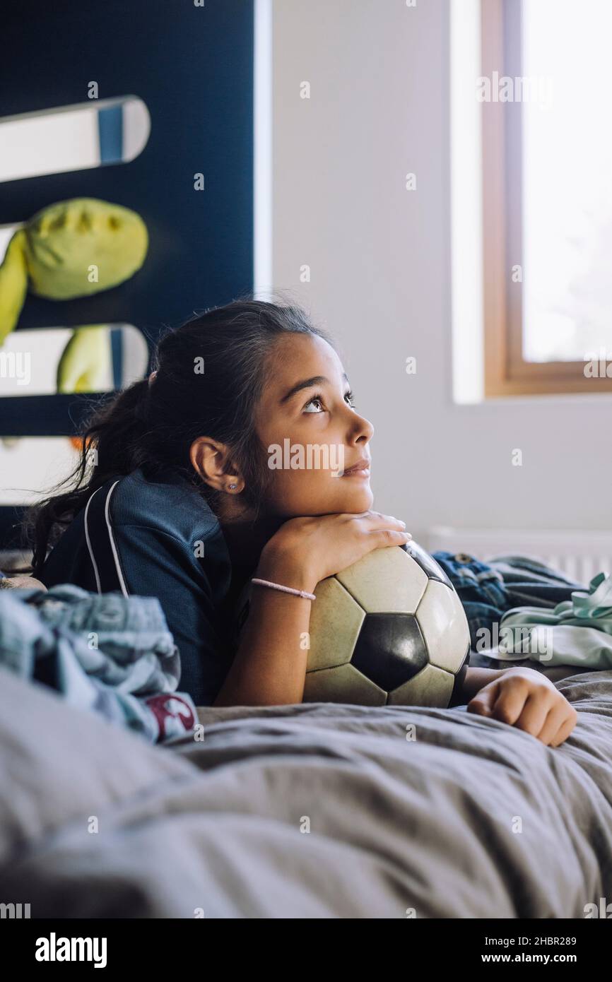 Ragazza giorno sognando mentre sdraiato a letto a casa Foto Stock