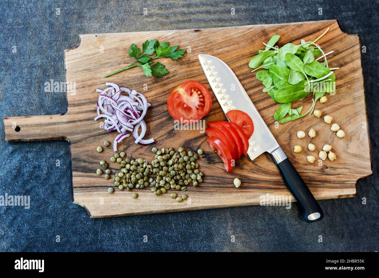 Verdure appena tagliate su un tagliere con un coltello dello chef Foto Stock