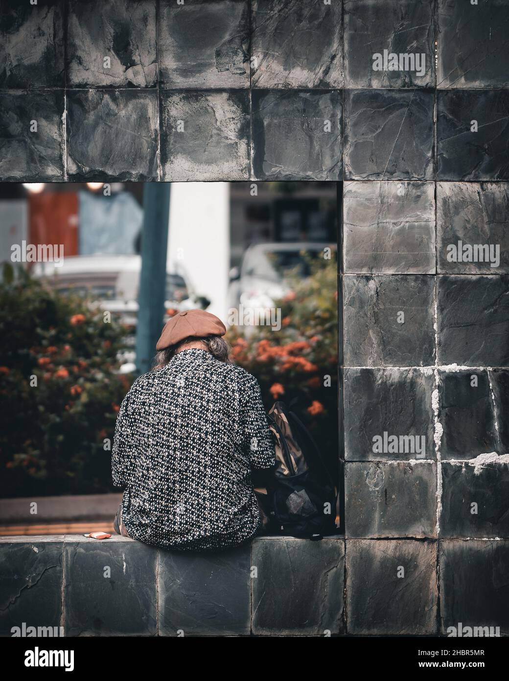 SINGAPORE, SINGAPORE - Nov 13, 2021: Un colpo verticale di una persona anziana seduta da sola per strada di Toa Payoh, Singapore Foto Stock