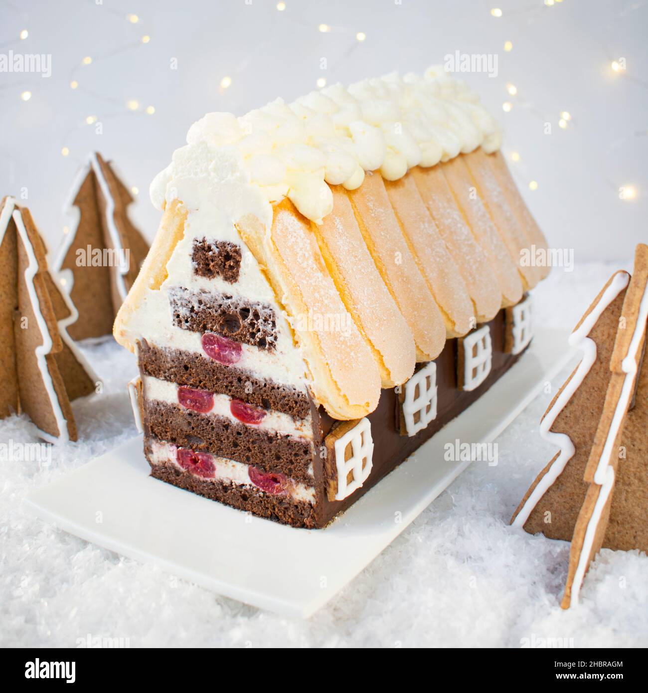Torta - cottage di Natale. Pan di Spagna con panna con aggiunta di ciliegie. Foto Stock