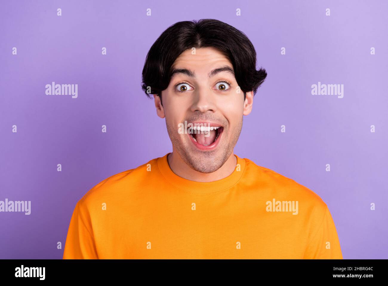 Foto di stupito scioccato eccitato felice uomo buon umore godere di sconto isolato su sfondo di colore viola Foto Stock