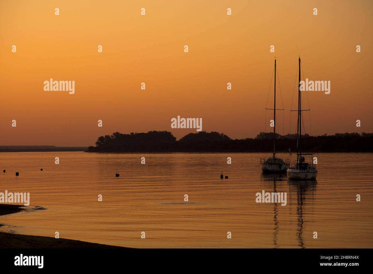 Barche a vela ancorate al tramonto sul fiume Uruguay. Colón, Entre Ríos, Argentina Foto Stock