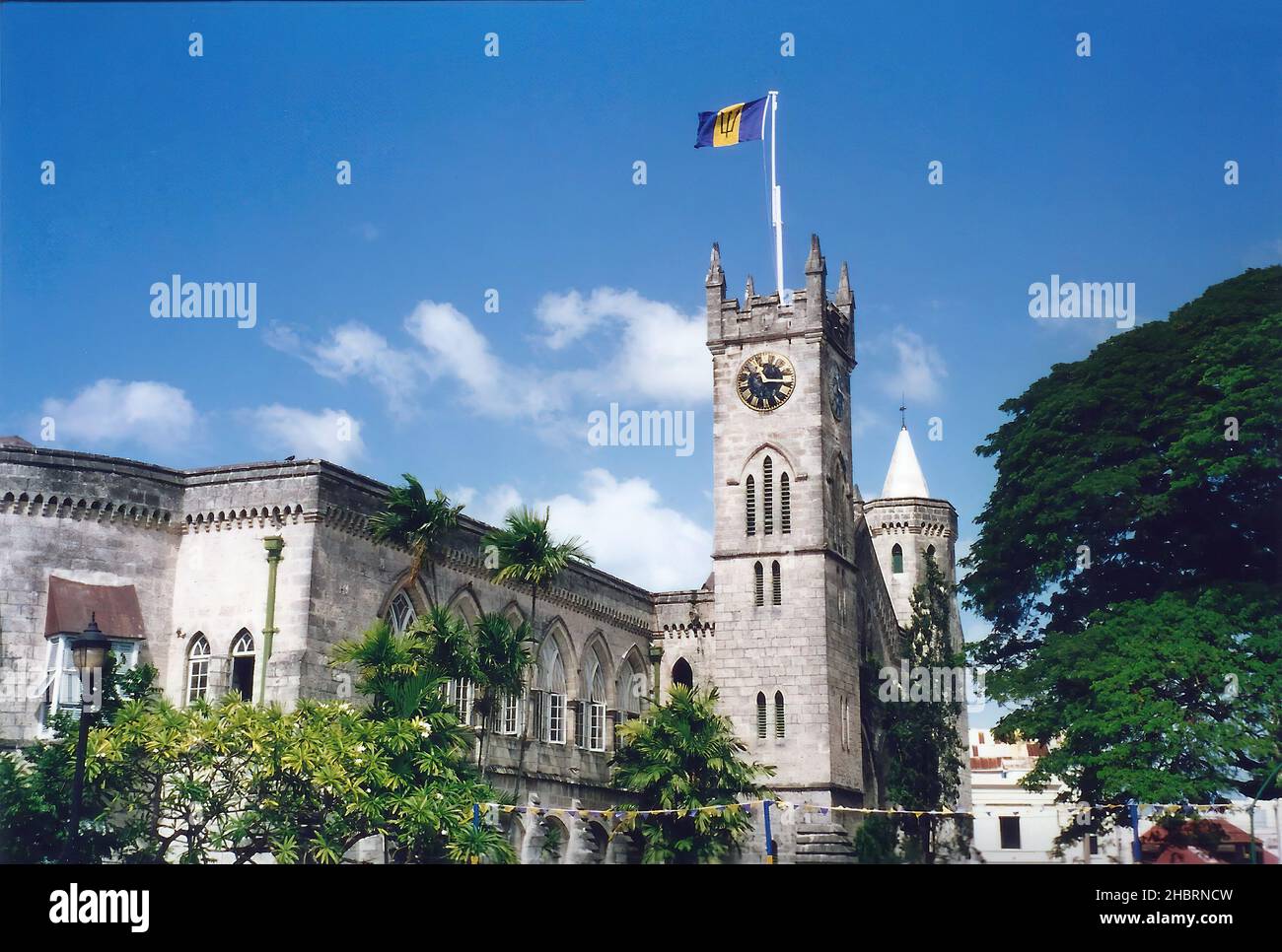 La bandiera nazionale che vola sopra la Torre dell'Orologio dell'edificio del Parlamento a Bridgetown, Barbados Foto Stock