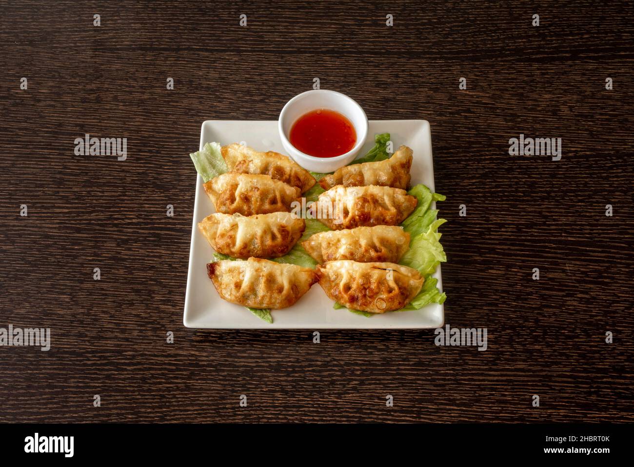 Gyozas giapponese o gnocchi sono immersi in salsa sulla strada per la vostra bocca. Il nostro è un misto di aceto di riso e salsa di soia Foto Stock