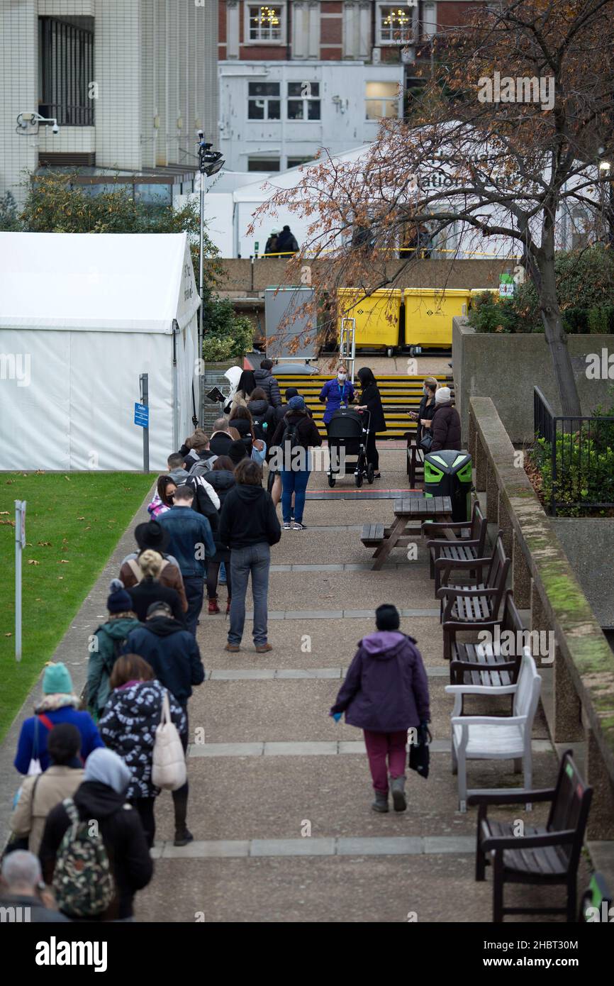 Le persone sono viste fare la fila verso un centro di vaccinazione al St Thomas’ Hospital nel centro di Londra. Foto Stock