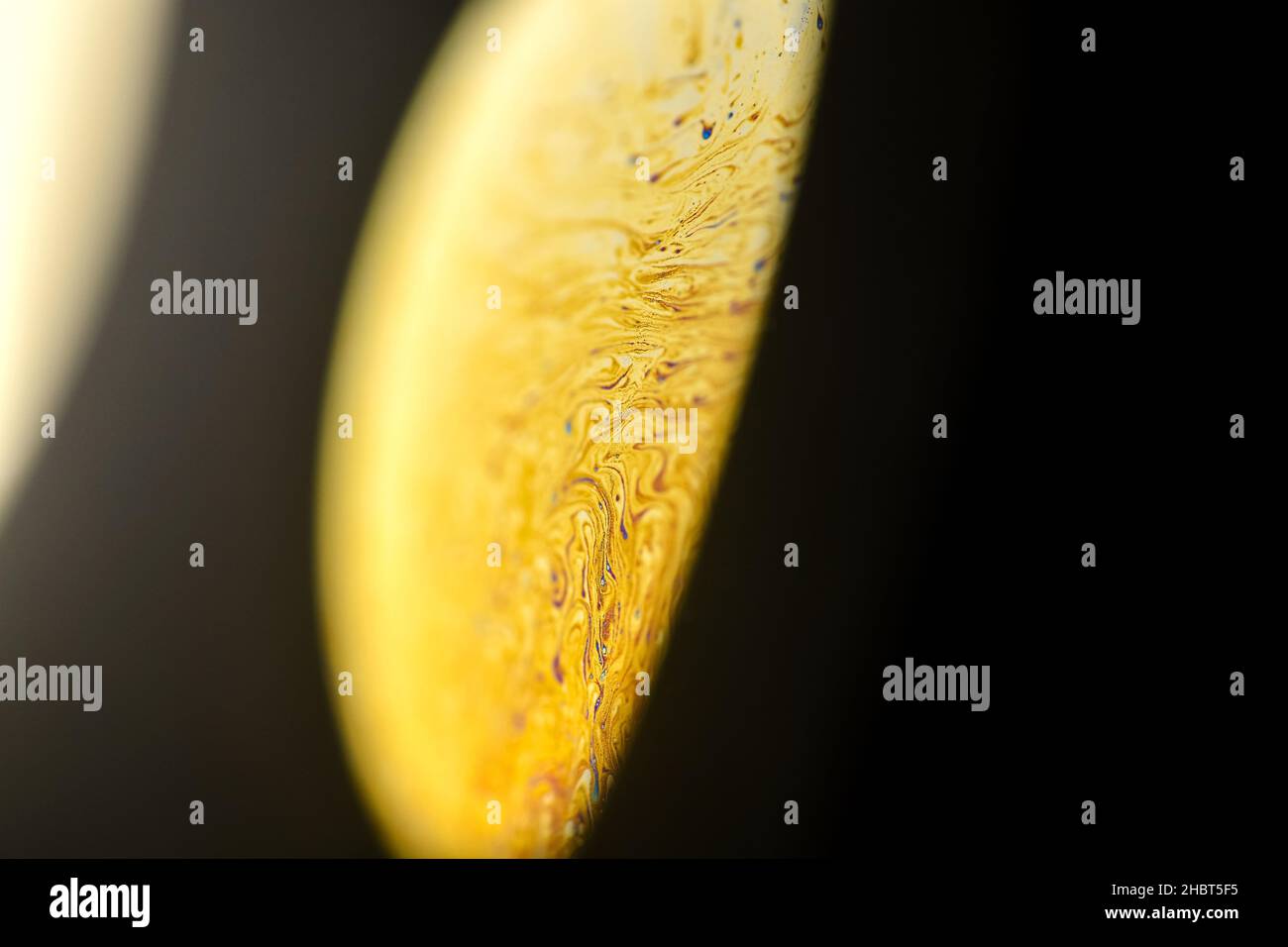 Primo piano bolla di sapone astratto, come ruotare fuori il completamente illuminato da un satellite giallo pianeta alieno in universo su sfondo scuro Foto Stock