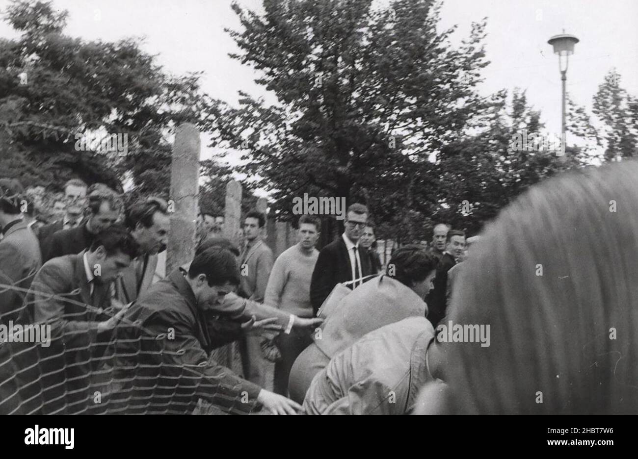 26 agosto 1961. Mentre i berlinesi occidentali distraggono le guardie della Germania orientale, alcuni fortunati berlinesi orientali lo fanno sopra la recinzione alla libertà Foto Stock