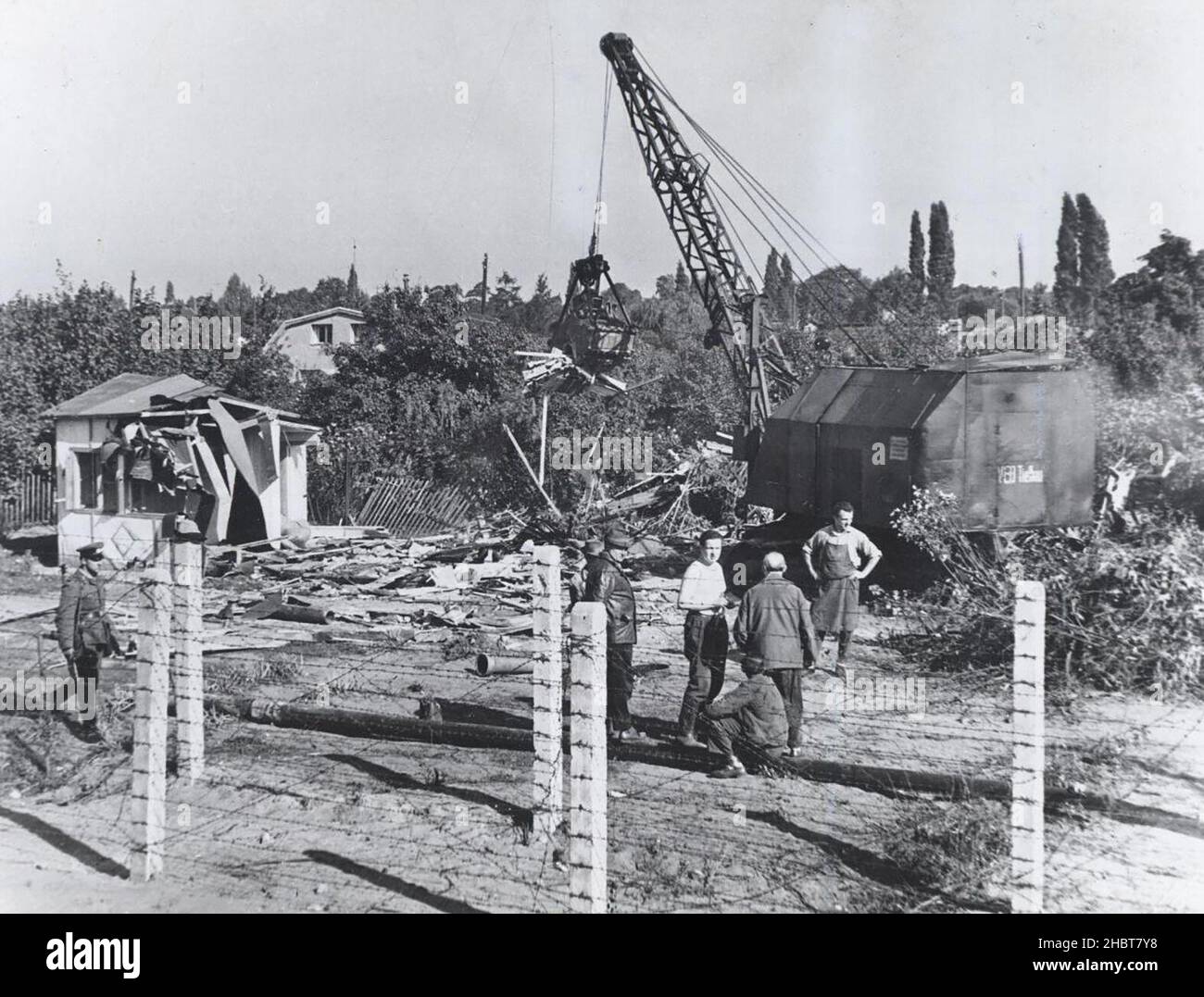 Ottobre 1961. I lavoratori della Germania orientale abbattere una casa al confine con Berlino Ovest, rimuovendo la copertura per coloro che cercano di fuggire in Occidente Foto Stock