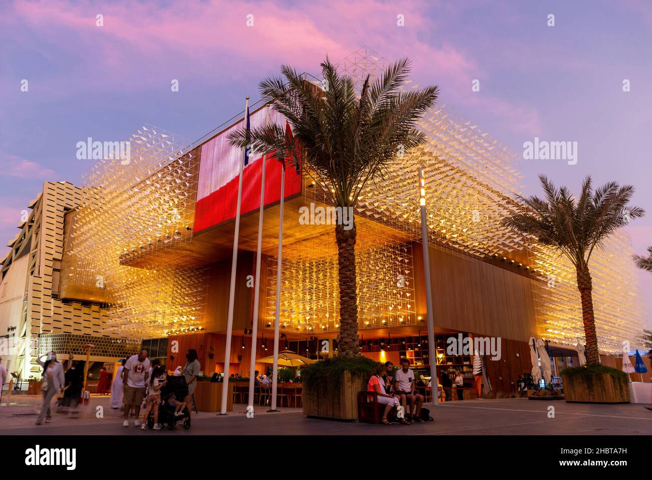 Dubai, Emirati Arabi Uniti, 09.12.2021. Padiglione illuminato della Polonia all'Expo 2020 di Dubai, con facciata in legno coperta da sculture raffiguranti uccelli volanti e polacchi Foto Stock