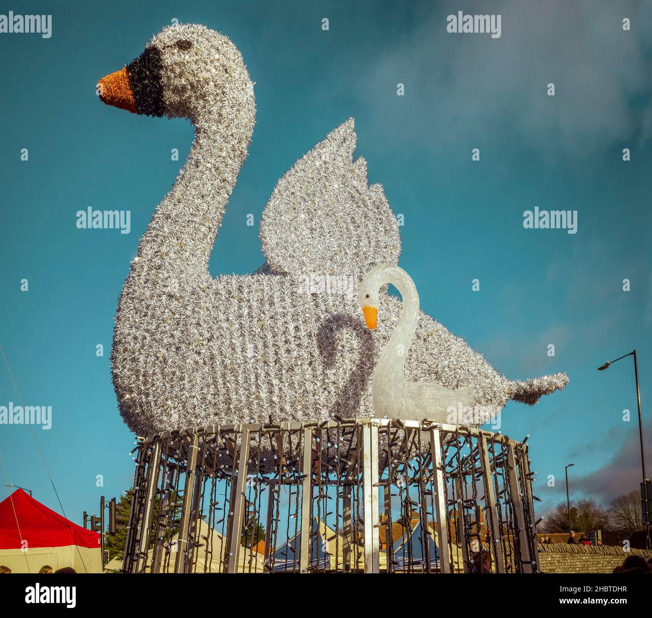 Stratford upon Avon, Regno Unito - Una splendida decorazione stradale che presenta un cigno e un cartello in piedi tra le bancarelle del mercato vittoriano di Natale. Foto Stock
