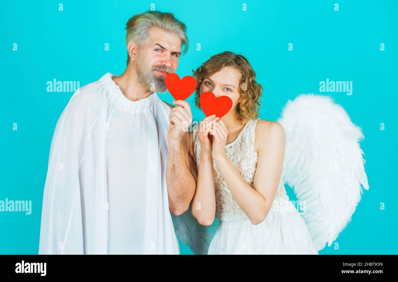 Festa di San Valentino. Coppia felice con cuori di carta rossa. Angeli Cupido con ali bianche. Amore. Foto Stock