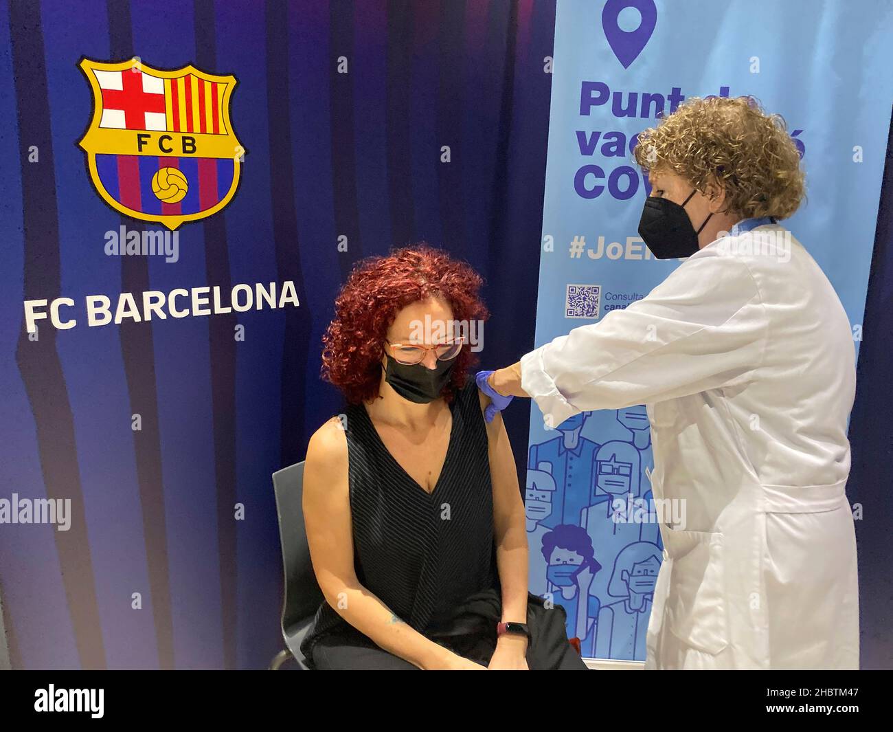 La persona viene vista vaccinata davanti al simbolo del FC Barcelona.per accelerare la vaccinazione del COVID-19, il Futbol Club Barcelona ha offerto un Foto Stock