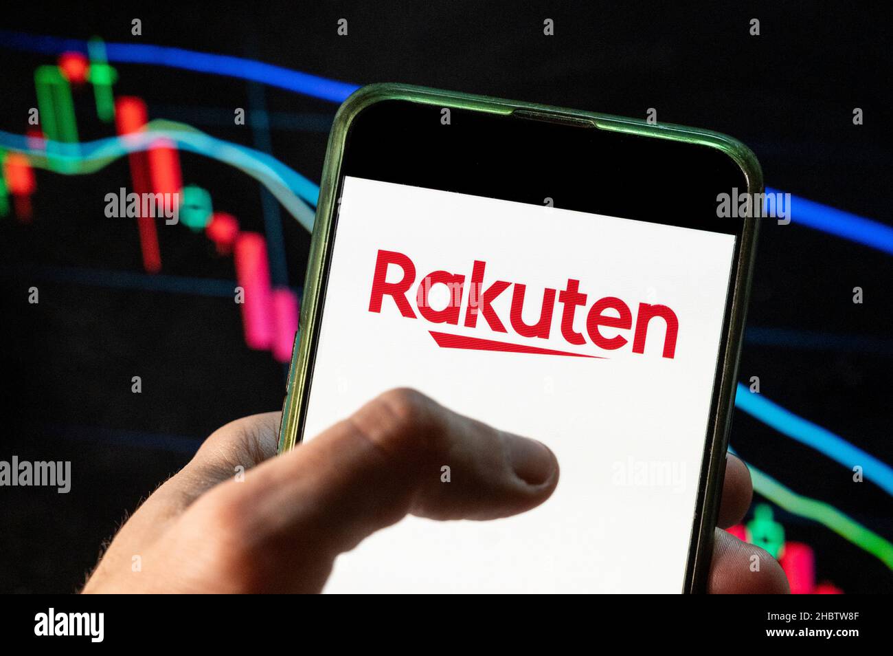 Cina. 09th Dic 2021. In questa foto raffigura il logo Rakuten, società giapponese di commercio elettronico e Internet, visualizzato su uno smartphone con un grafico dell'indice delle borse economiche sullo sfondo. (Foto di Budrul Chukrut/SOPA Images/Sipa USA) Credit: Sipa USA/Alamy Live News Foto Stock