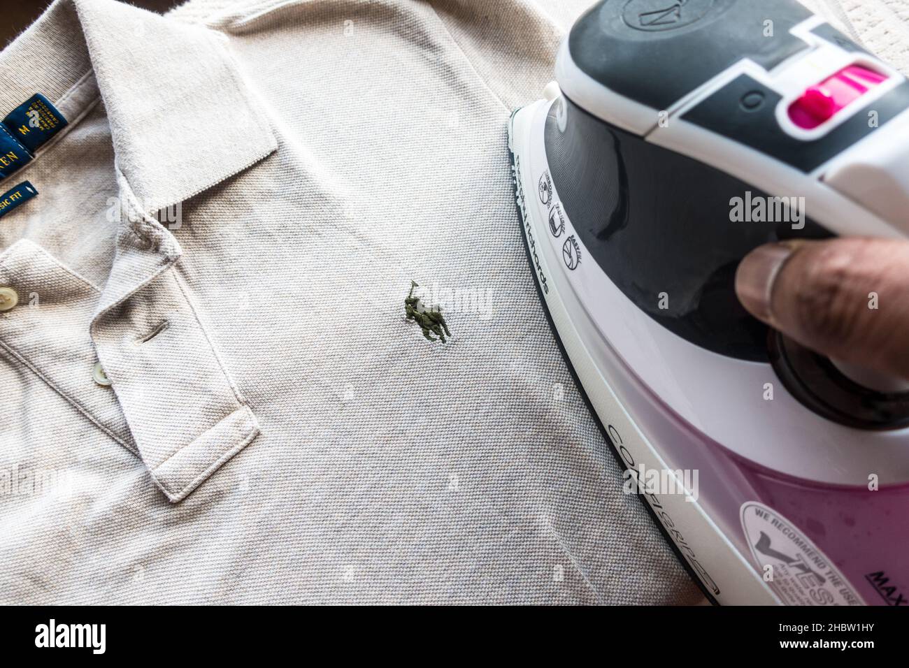 Abbigliamento polo maschile indiano per adulti di mezza età su un supporto in ferro borad Foto Stock