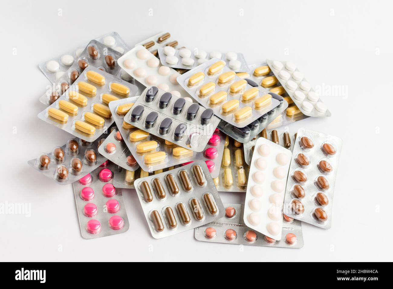 Primo piano di diversi farmaci pillole, compresse e vitamine isolato su sfondo bianco, immagine farmaceutica scattata con soft focus Foto Stock