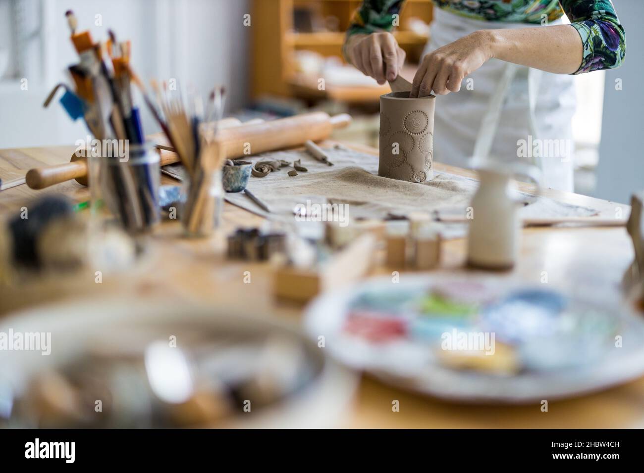 Primo piano di artigiani che lavorano in ceramica in officina Foto Stock