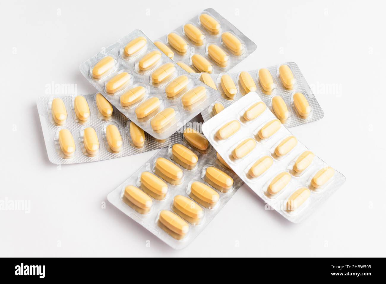 Primo piano di diversi farmaci pillole, compresse e vitamine isolato su sfondo bianco, immagine farmaceutica scattata con soft focus Foto Stock