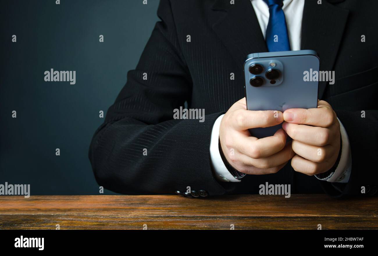 Kherson, Ucraina, 2 dicembre 2021: IPhone 13 pro max di colore blu nelle mani di un uomo d'affari. Comunicazione nel mondo degli affari, del lavoro online e dello shopping Foto Stock