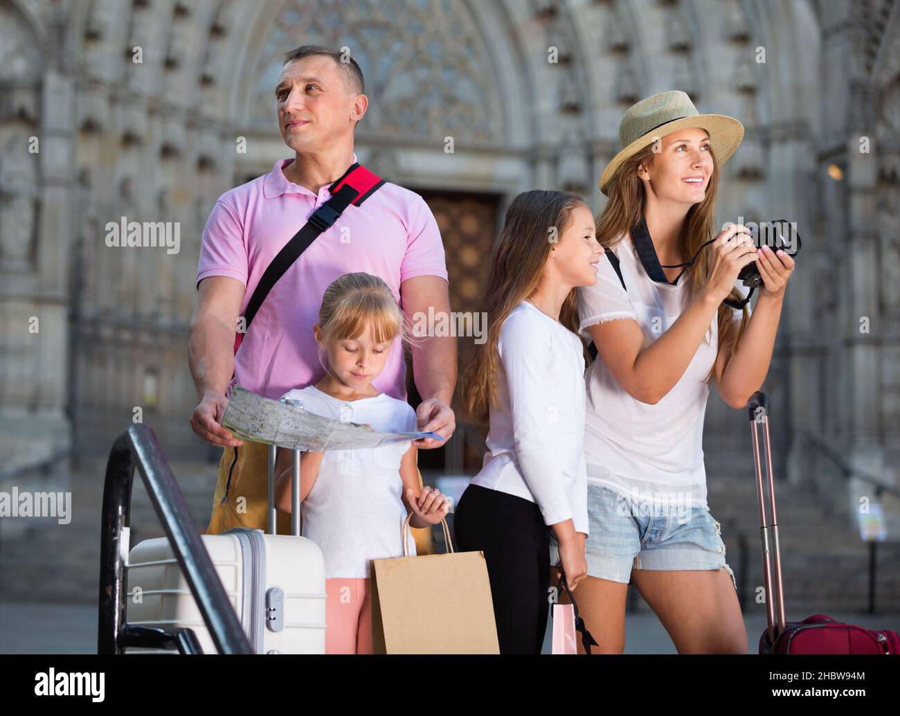 Famiglia turistica che usa la mappa e scatta foto della città mentre passeggi Foto Stock