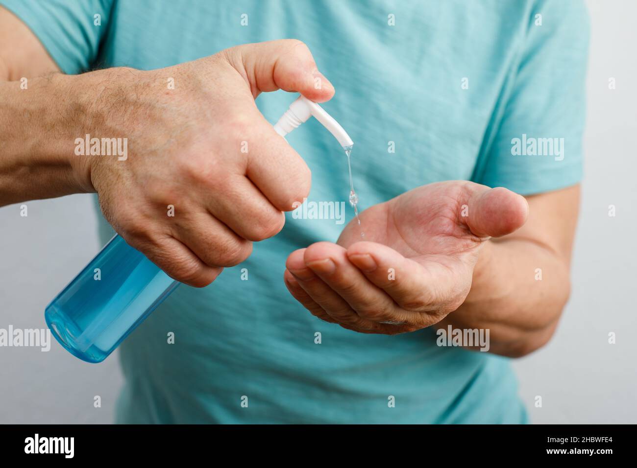 Uomo che usa l'igienizzatore per le mani. Igienizzante fai-da-te. Igiene personale durante coronavirus o pandemia COVID-19 Foto Stock