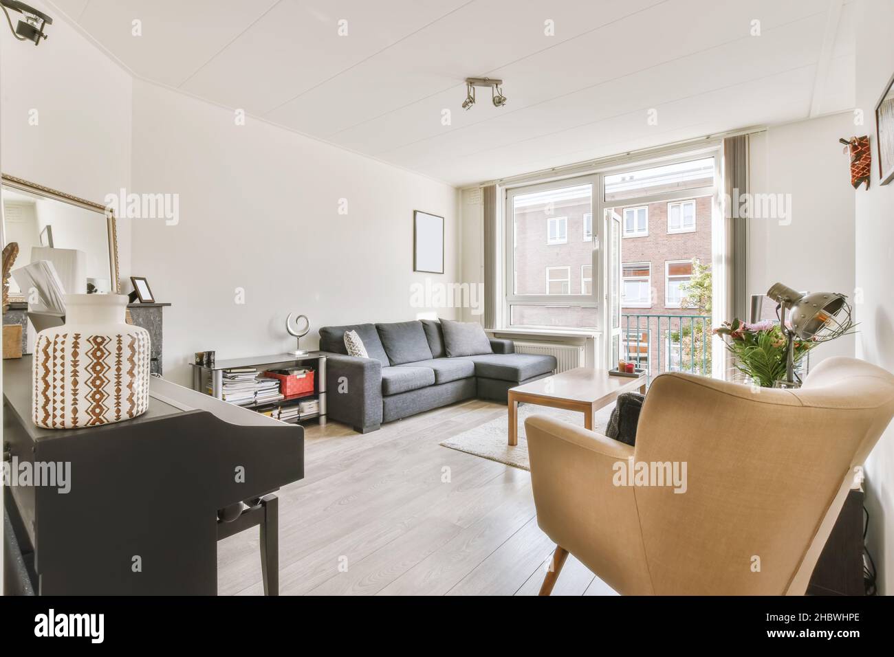 Accogliente soggiorno con divano nero e tavolino in legno Foto Stock