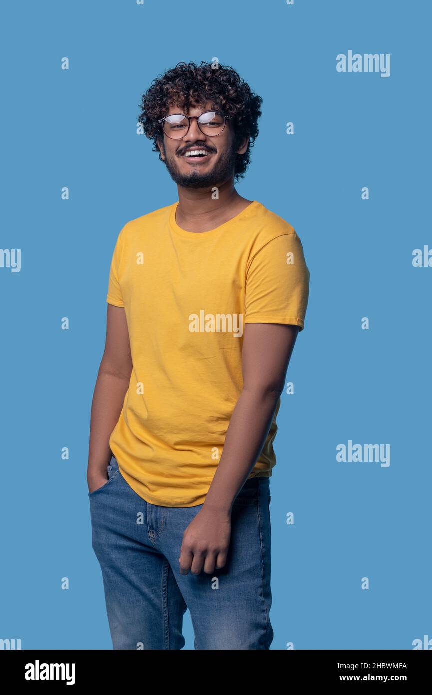 Ragazzo carino con un sorriso toothy che indossa occhiali rotondi Foto Stock