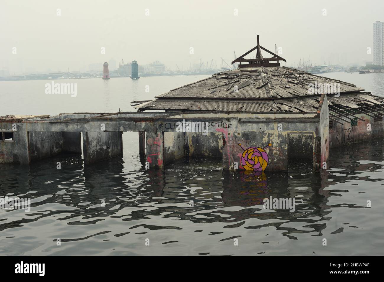 Un edificio della moschea che è stato abbandonato per decenni a causa dell'aumento del livello del mare, l'abrasione costiera e la sussistenza della terra sulla zona costiera di Jakarta, Indonesia. Foto Stock