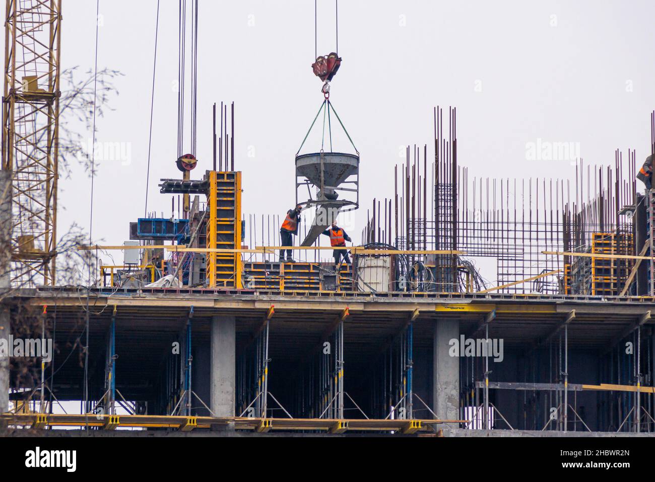 Elevare la miscela concreta all'orizzonte o al pavimento di montaggio per riempire la cassaforma di una struttura monolitica, fuoco selettivo Foto Stock