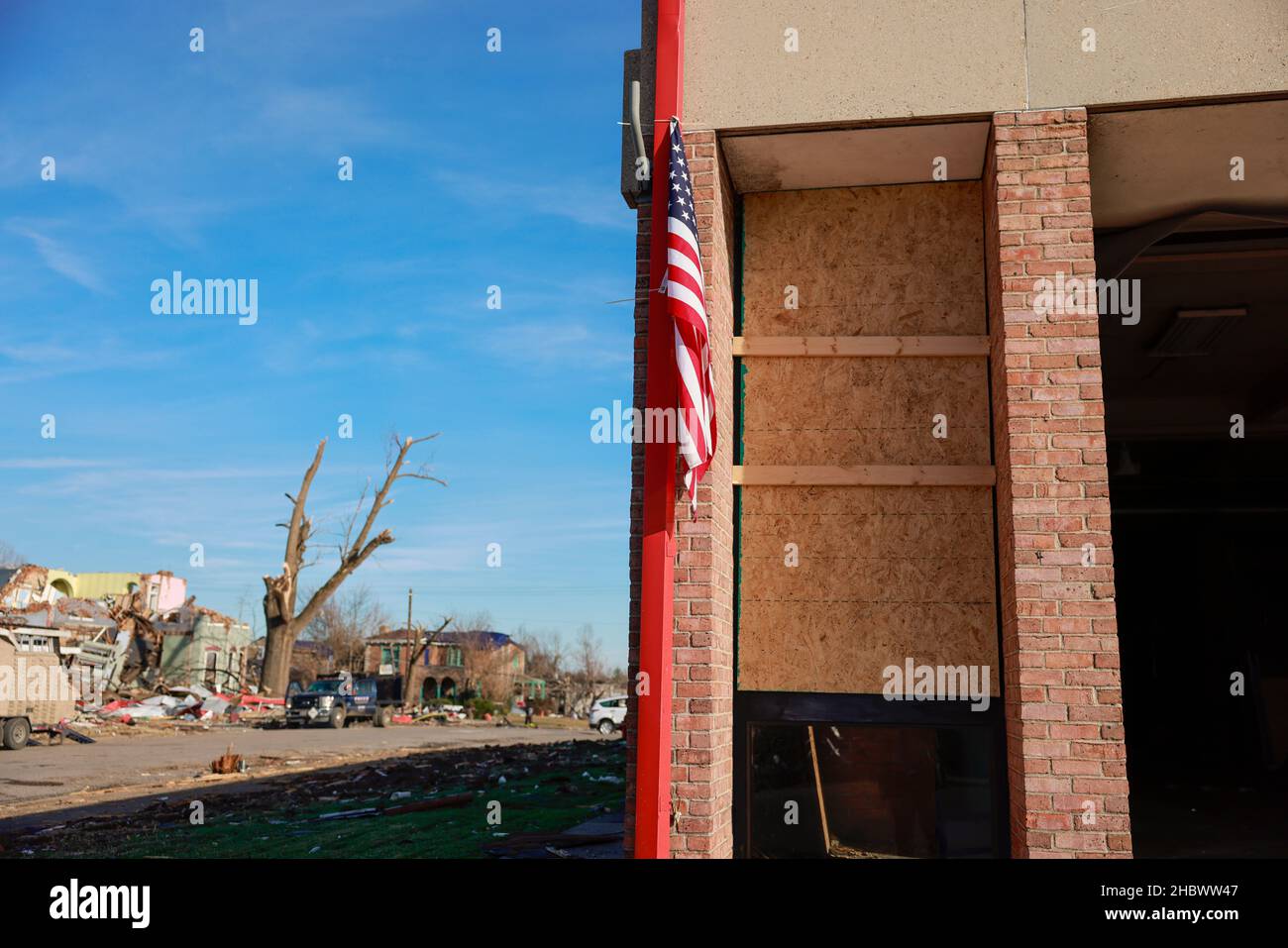 MAYFIELD, KENTUCKY - DICEMBRE 20: Una bandiera appende fuori di una stazione dei vigili del fuoco pesantemente danneggiata, il 20 Dicembre 2021 a Mayfield, Kentucky. Numerosi tornado notturni hanno colpito diversi stati del Midwest il 10 dicembre, causando una distruzione diffusa e numerose vittime. Foto Stock