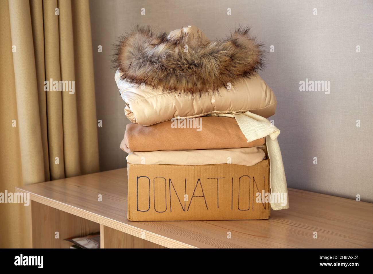 Confezione da donazione con abiti invernali sul tavolo. Foto Stock