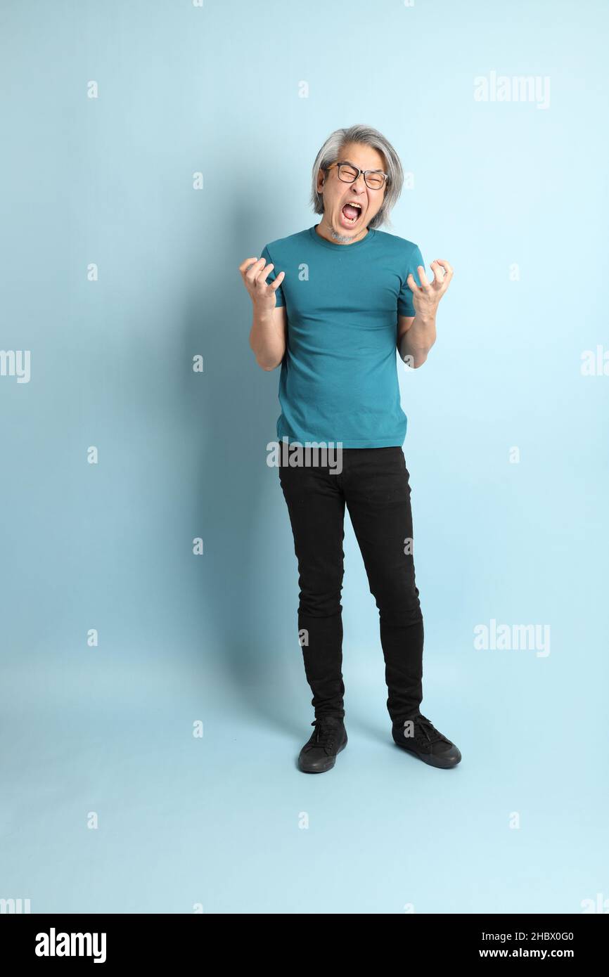 L'uomo asiatico più anziano su sfondo blu. Foto Stock