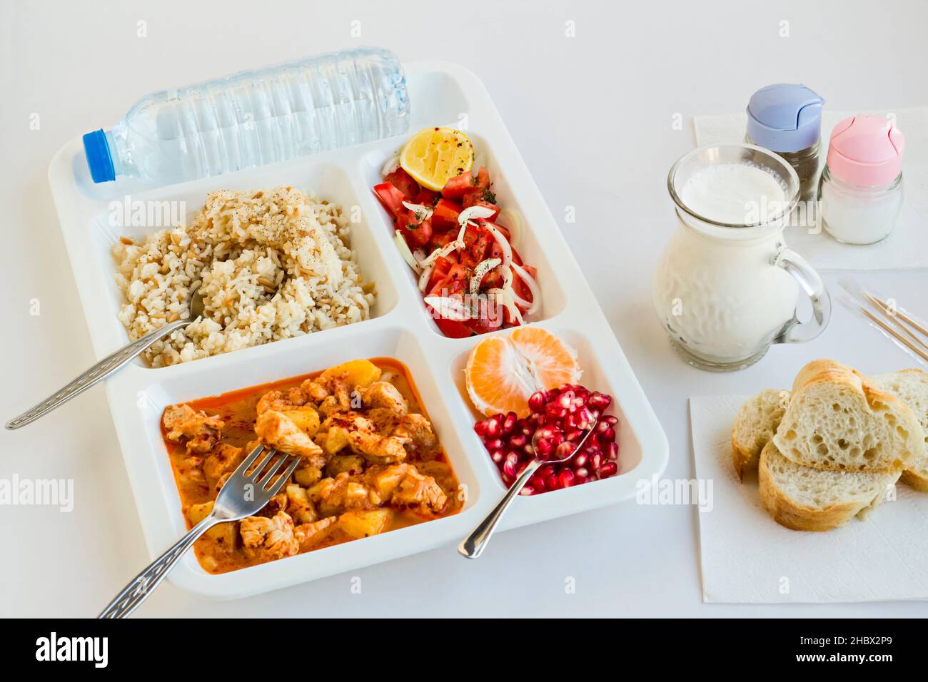 Tradizionale pasto turco con patate di pollo, riso, insalata di pomodoro e frutta in vassoio di cibo bianco. Table d'hote-known TABLDOT in TR- Foto Stock