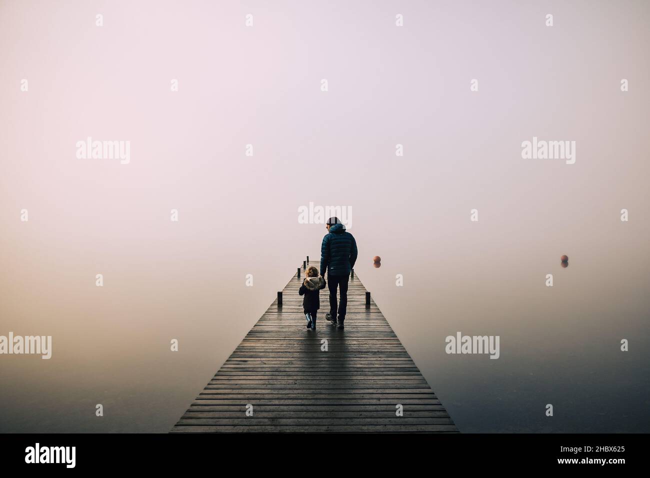 Bella nebbia suggestiva mattina nel Lake District con padre e figlio Foto Stock