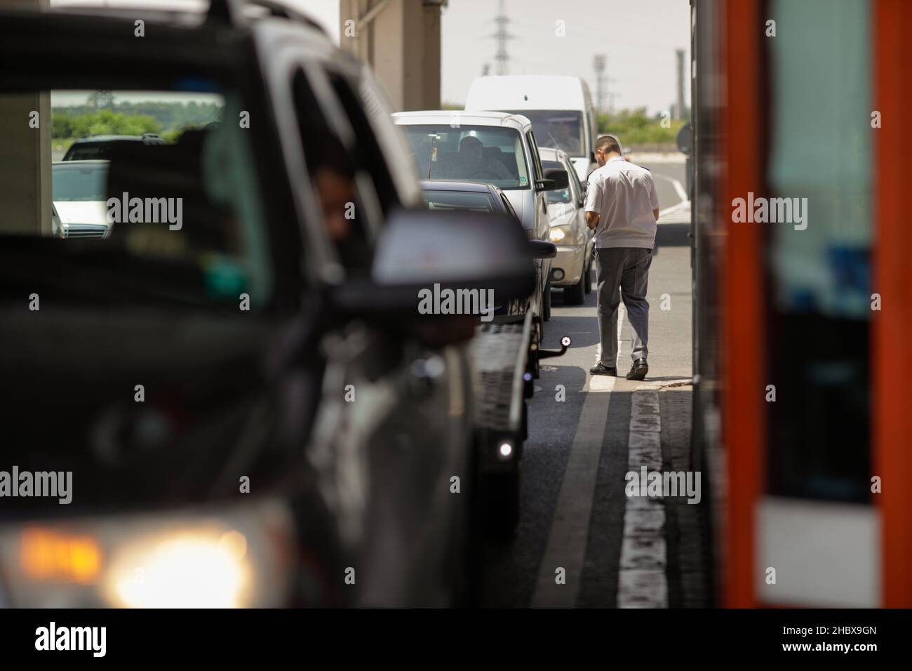 Giurgiu, Romania - 1 luglio 2021: L'ufficiale di polizia di frontiera controlla i documenti dei conducenti alla frontiera terrestre e alle dogane tra Bulgaria e Romania. Foto Stock