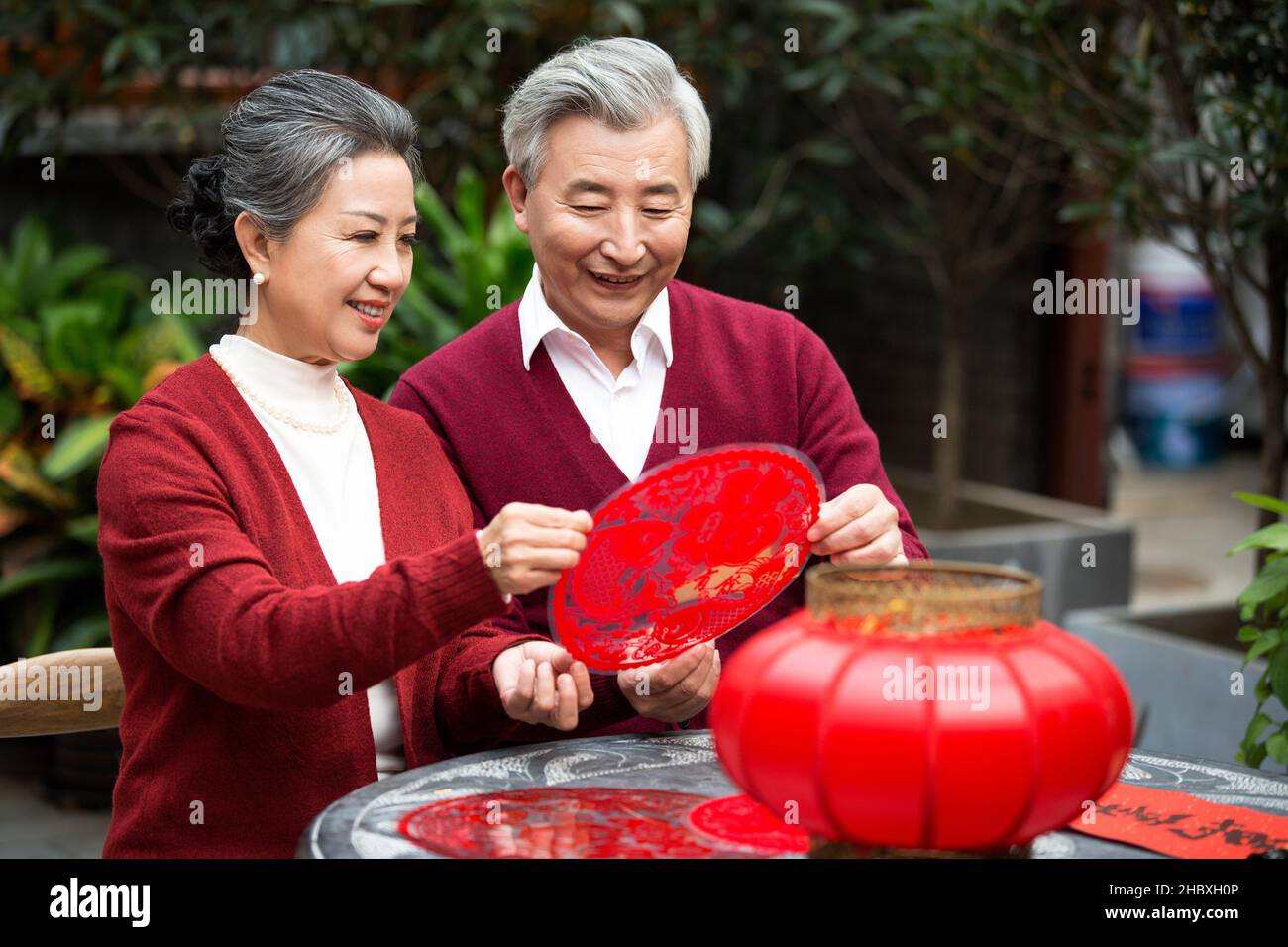 Felice vecchia coppia cutig nuovo anno fiori finestra Foto Stock