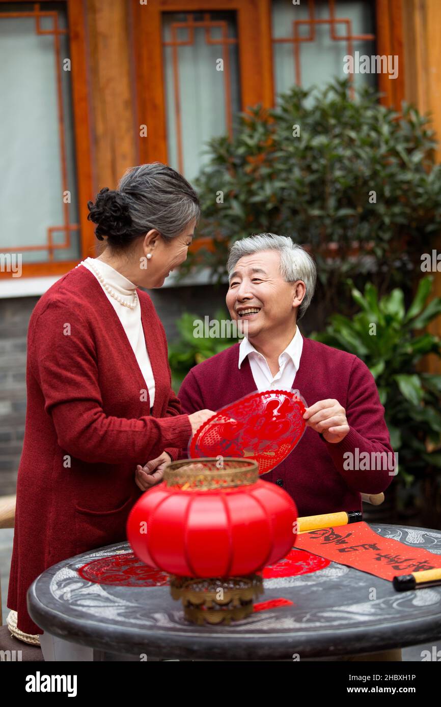 Felice coppia vecchia che fa le decorazioni di nuovo anno Foto Stock