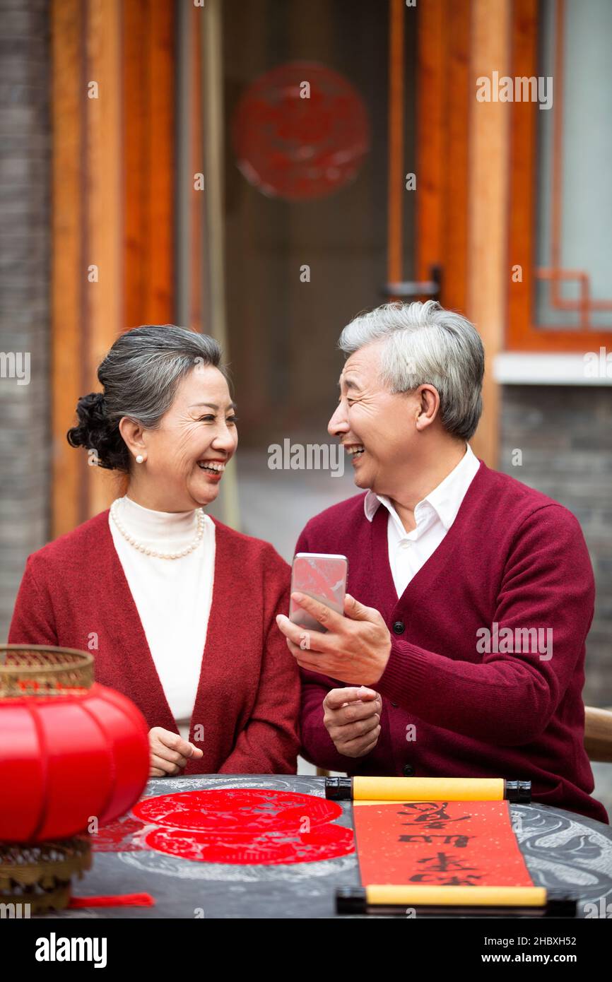 Coppie anziane che usano smartphone per videochiamare nel nuovo anno Foto Stock