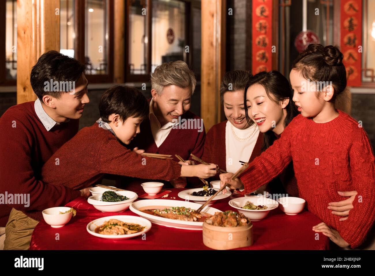 Famiglie felici che mangiano la cena la vigilia di Capodanno Foto Stock