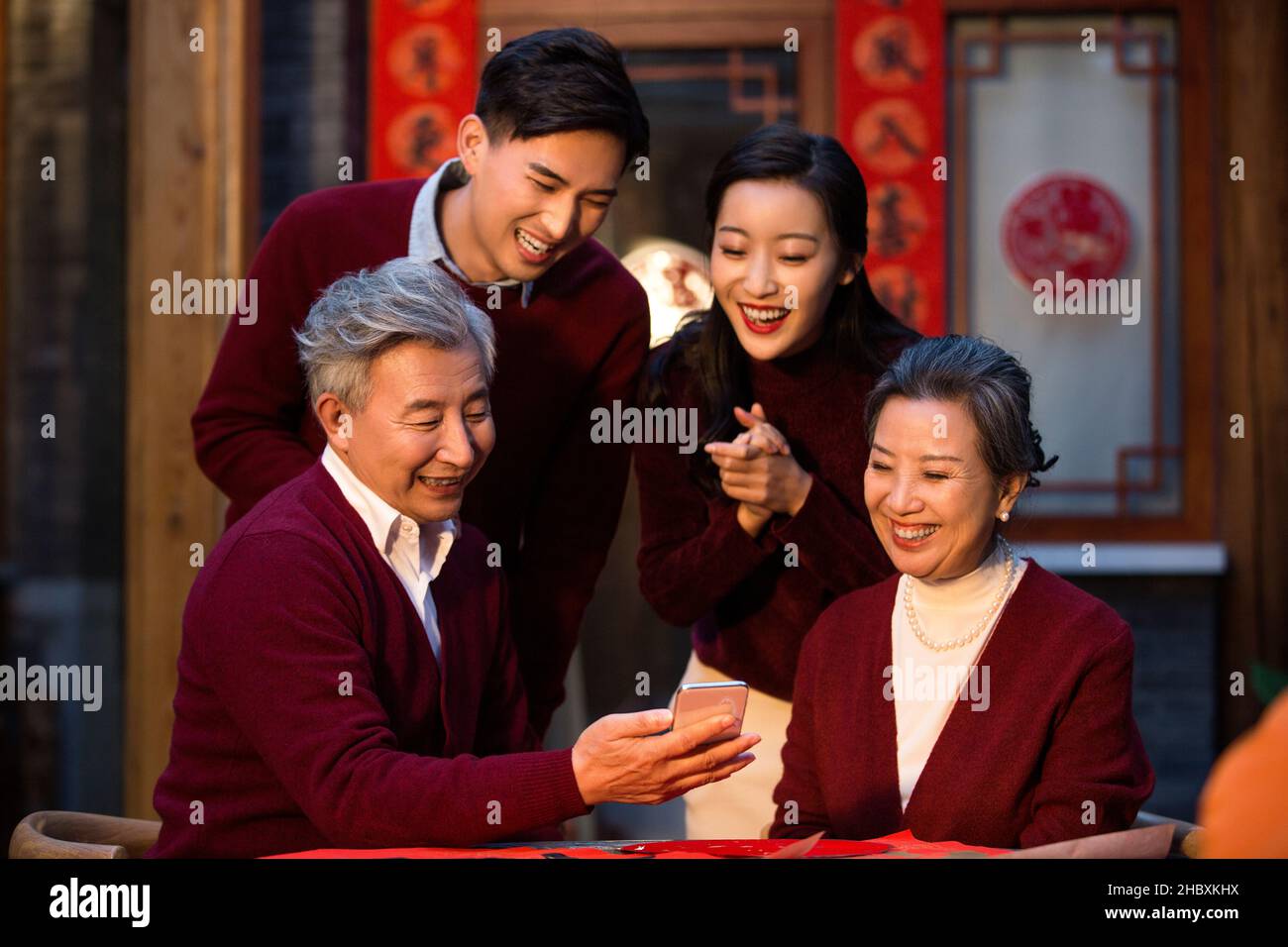 Buona famiglia che utilizza il proprio smartphone per le videochiamate nel nuovo anno Foto Stock