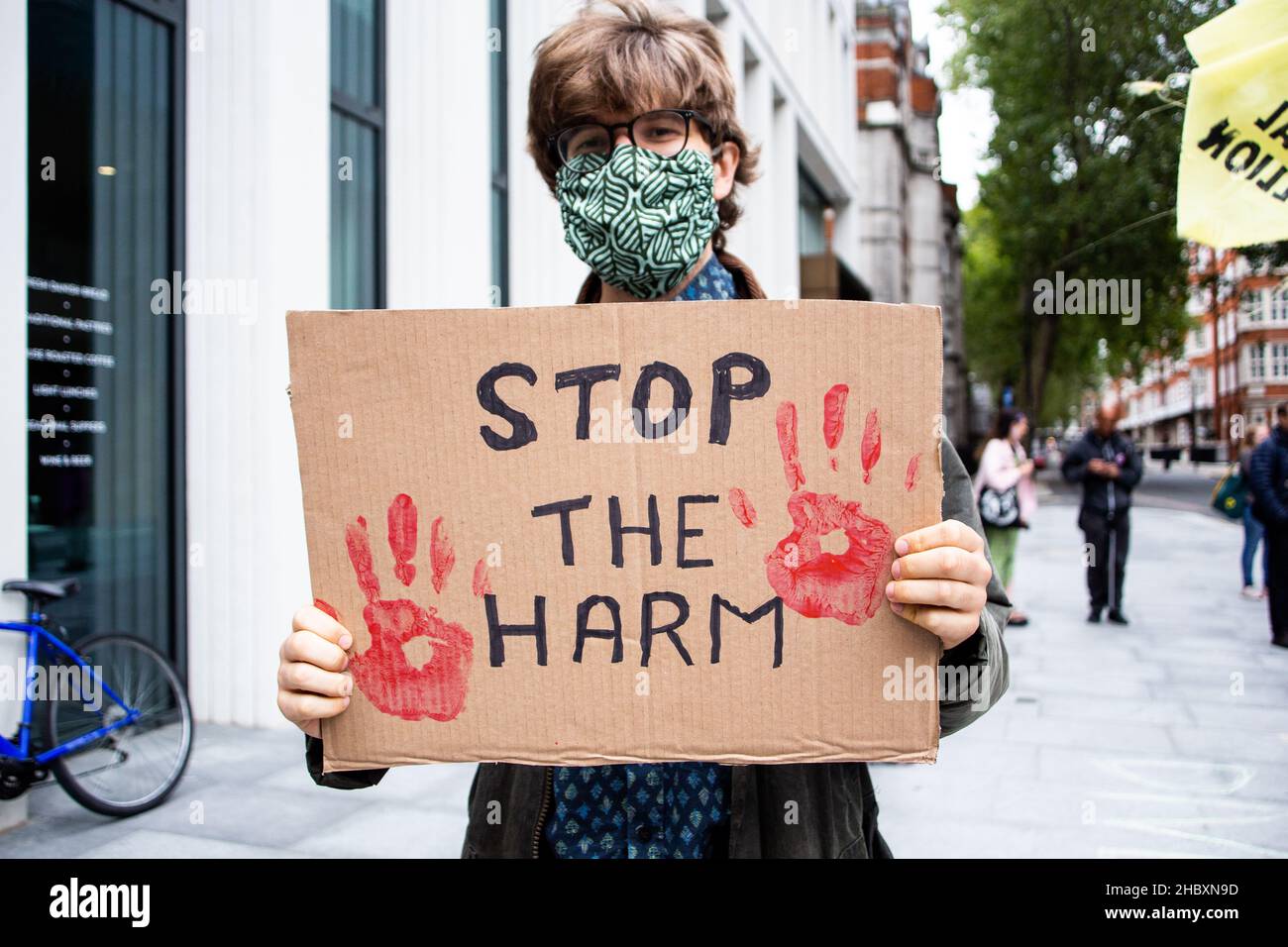 Il protestore del clima che tiene il segno manoscritto che dice Stop the HARM, Londra 2022 Foto Stock