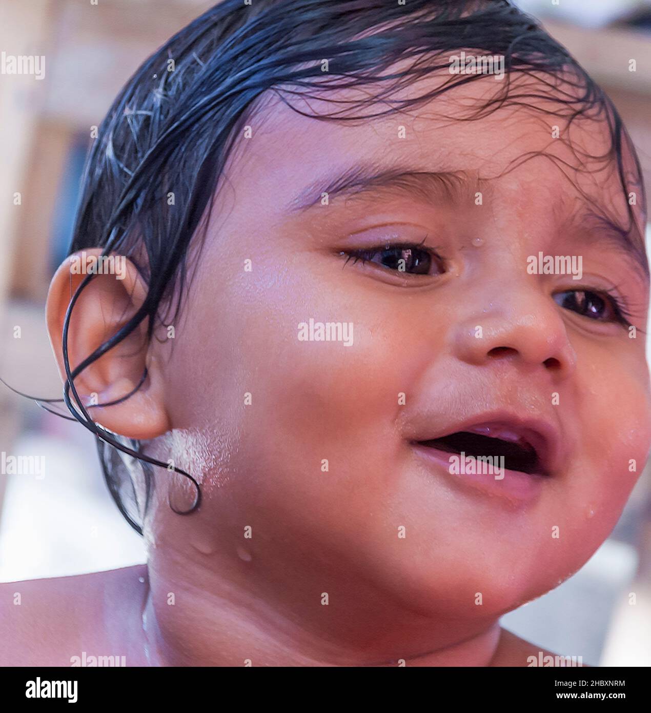 Un bambino indiano / indiano orientale / indiano asiatico sorridendo mentre prende un bagno. Foto Stock